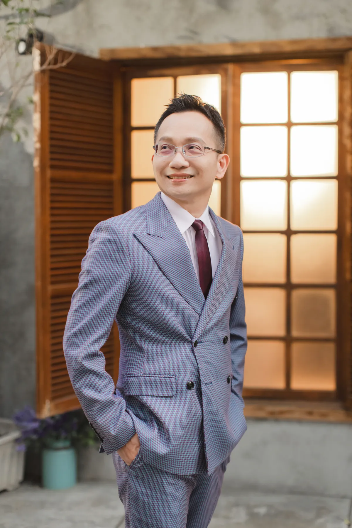吳家德穿雙排扣西裝站在木窗前